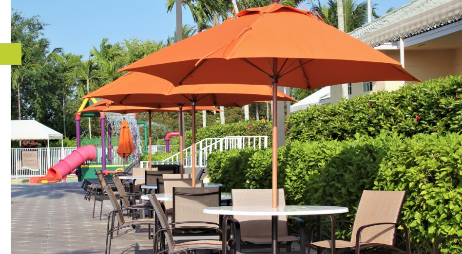 Three orange umbrellas covering patio tables