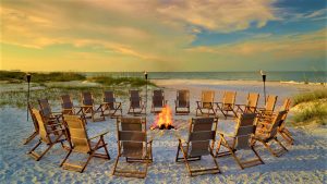 Deck chairs around a fire on the beach