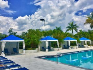 Row of blue topped pavilions on pool deck